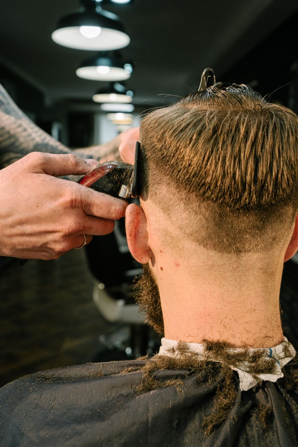 Barbero cortando el cabello de un cliente